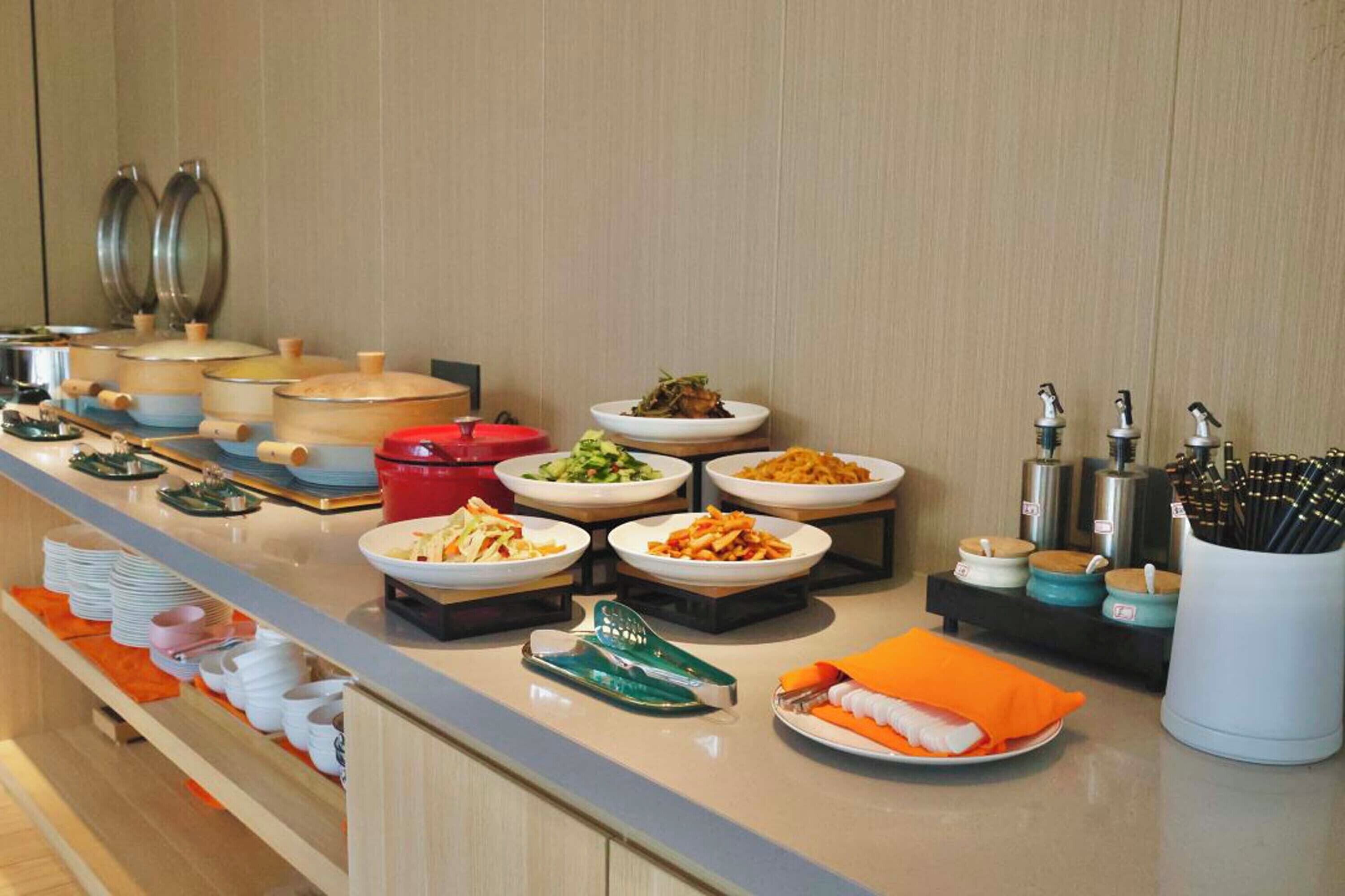 Un buffet proposant divers plats et ustensiles.
