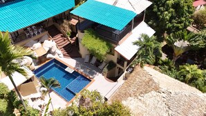 Il s’agit d’une propriété résidentielle dotée d’une piscine, d’un espace extérieur aménagé et d’un escalier menant à un balcon.