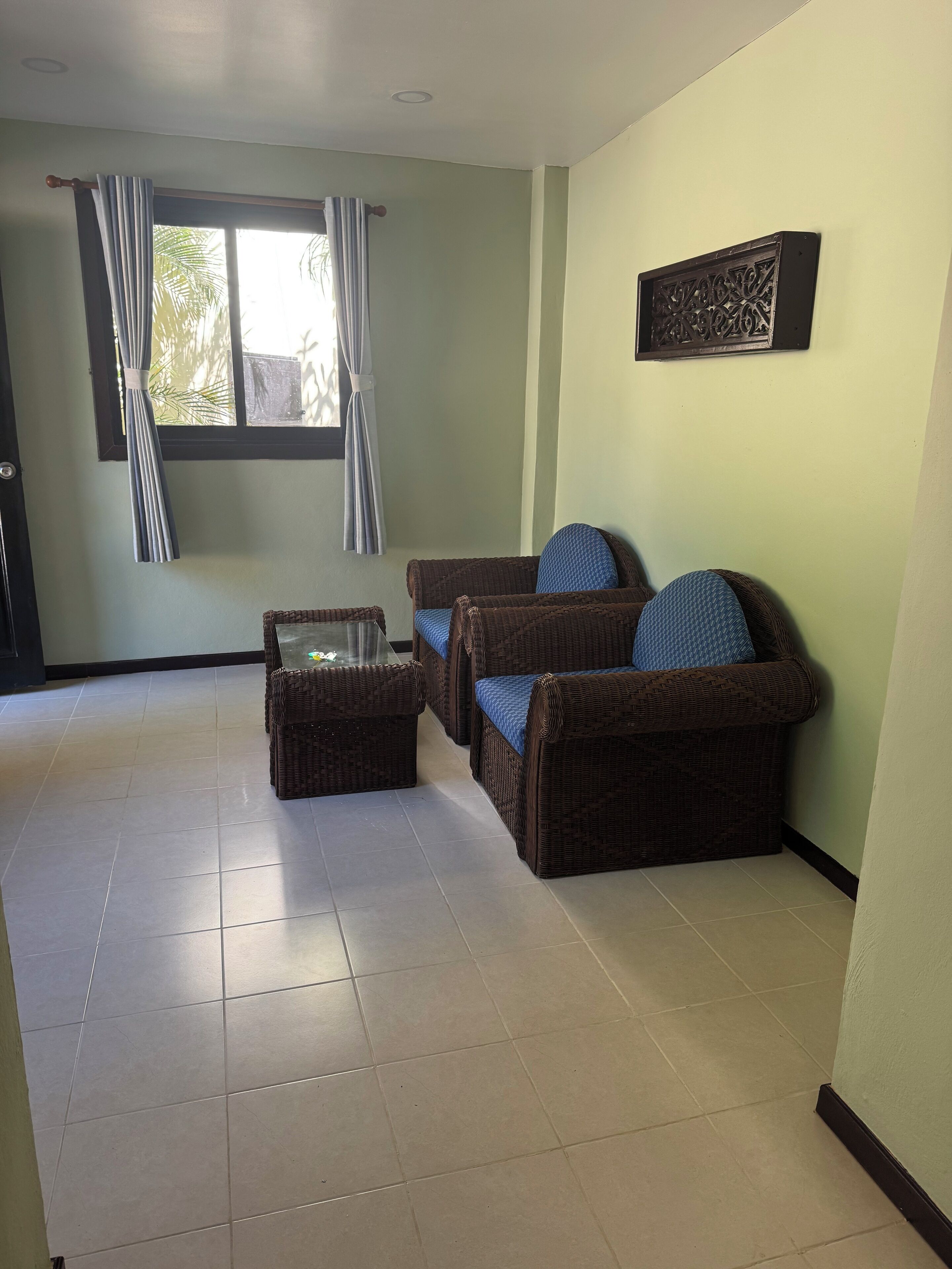 Una sala de estar con un sofá, una mesa de centro y una ventana con cortinas.