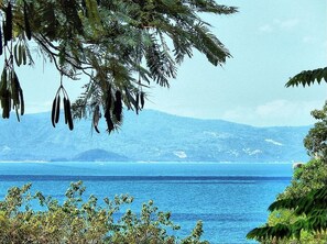 A coastal landscape with a clear view of the sea and distant mountains. - Little Hill (Ko Pha-ngan)