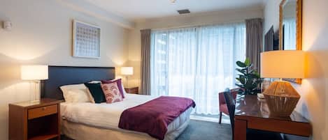 Escritorio, tabla de planchar con plancha, wifi y ropa de cama