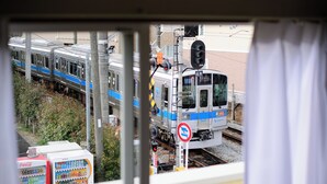 A train passing by a window with vending machines and a no parking sign. - Guest Villa Hakone Kazamatsuri (Odawara)