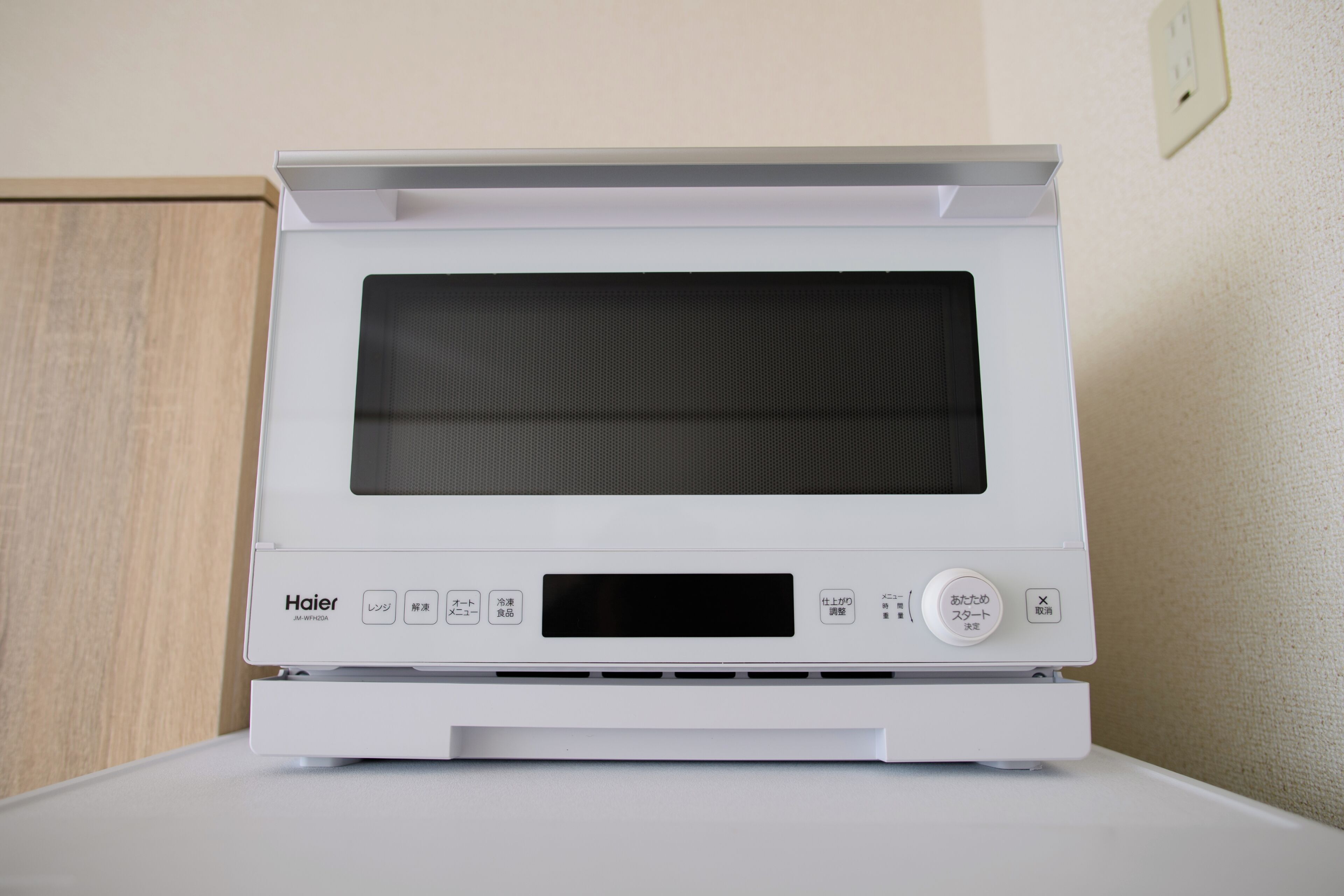 A white Haier microwave oven with a digital display and control buttons.