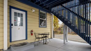 A yellow building with a white door, a small table and chairs, and a fire extinguisher on the wall. - Premium Cozy 1-bedroom apartment in fantastic Sacramento w/ AC and gym equipment (Sacramento)