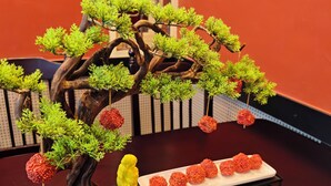 A bonsai tree with red fruits on a table. - JUN YUE Ikeja Lagos hotel (Lagos)