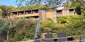 A multi-story building with balconies, surrounded by dense greenery. - Retreat Hotel ENTO ISESHIMA (Minamiise)