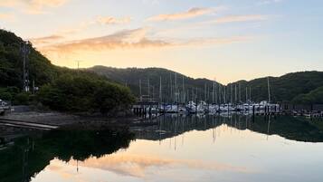 A marina with boats docked, surrounded by hills and a clear sky.
