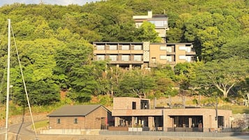 A multi-story building with a flat roof, surrounded by dense green foliage.