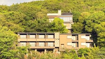 Un edificio moderno de varios pisos, rodeado de abundante vegetación.
