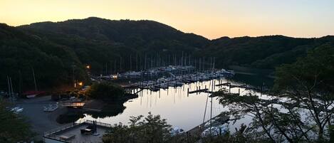 A marina with boats docked, surrounded by hills and trees.