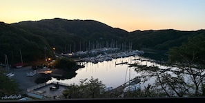 A marina with boats docked, surrounded by hills and trees.