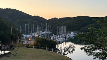 A marina with boats docked, surrounded by hills and greenery.
