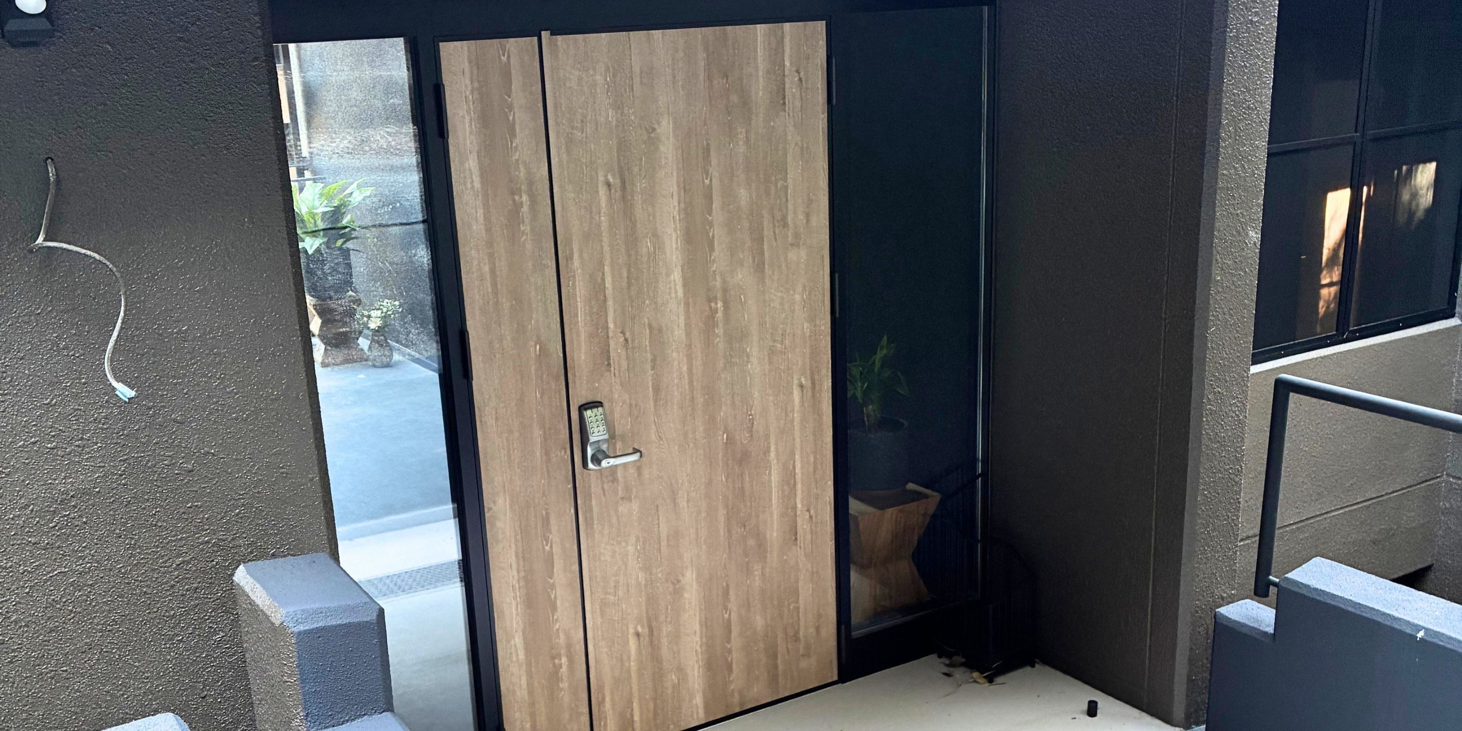 A room with a sliding door, a small window, and a visible outdoor area with plants.
