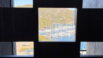 A view through a window of a marina with boats docked, surrounded by greenery.
