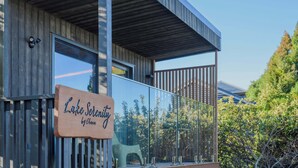 Ein modernes Gebäude mit Holzfassade, einer Glaseinfassung und einem Schild mit der Aufschrift 'Lake Serenity by Ohana'.