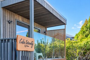 A modern building with a wooden facade, large windows, and a sign reading 'Lake Serenity by Ohana.' - Cozy Tekapo Studio | Lake + Church Views | Balcony (Lake Tekapo)