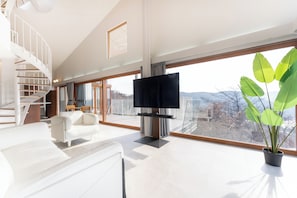 Villa panoramique, balcon, vue sur le lac | Aire de séjour | Téléviseur connecté de 65 po avec télévision numérique, lecteur de DVD