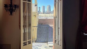 An open doorway leading to a balcony with a cityscape view. - Luxurious Rooftop French Quarter Penthouse (New Orleans)