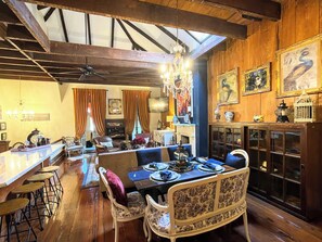 A dining area with a wooden ceiling, a chandelier, and a table set for four. - Luxurious Rooftop French Quarter Penthouse (New Orleans)