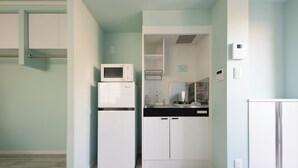 A compact kitchen with a refrigerator, microwave, and a small countertop.