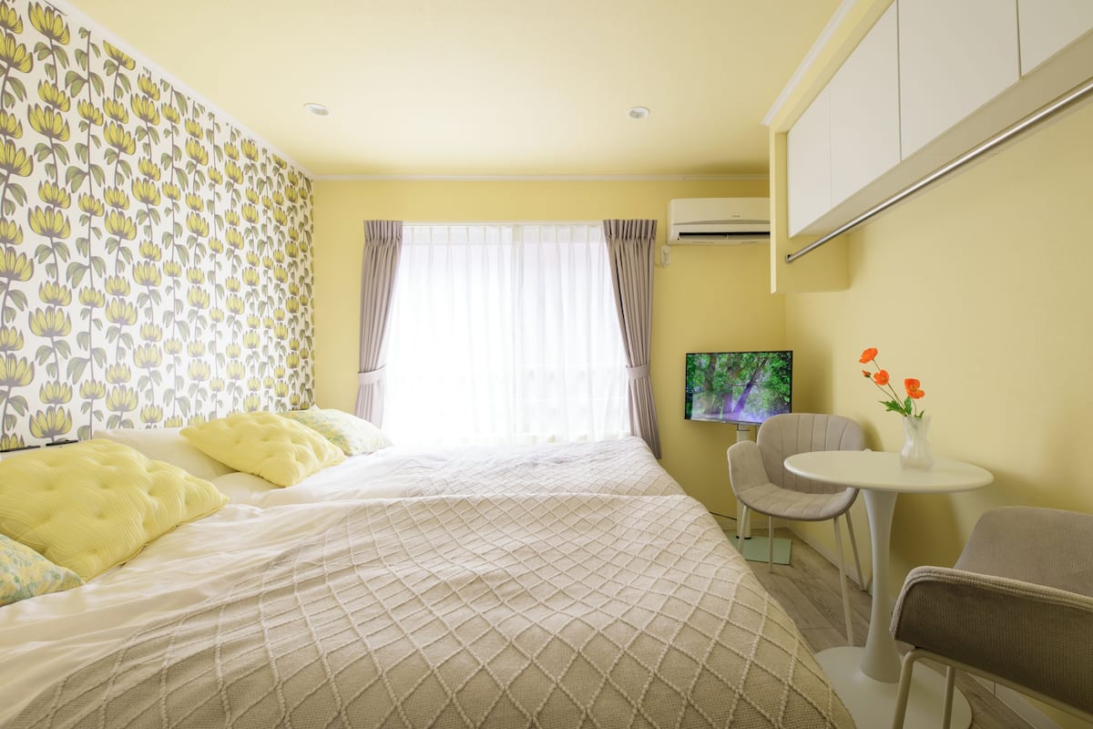 A hotel room with a bed, a small table, a chair, and a TV.