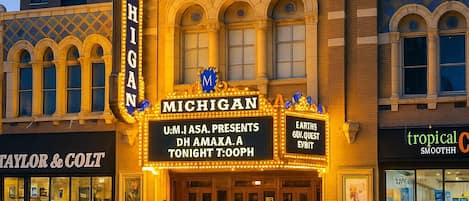 A theater with a marquee advertising a performance by U.M.I.A.S.A. and a presentation by Dh Amaka.