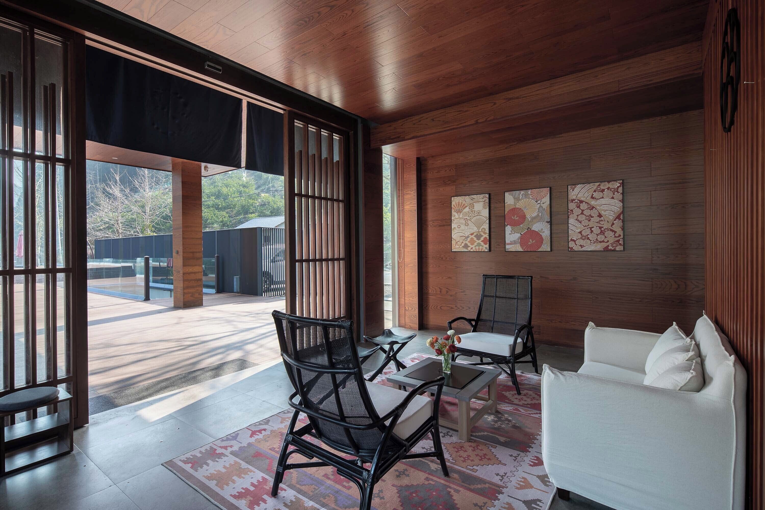 A modern interior with a white sofa, black chairs, and artwork on the wall.