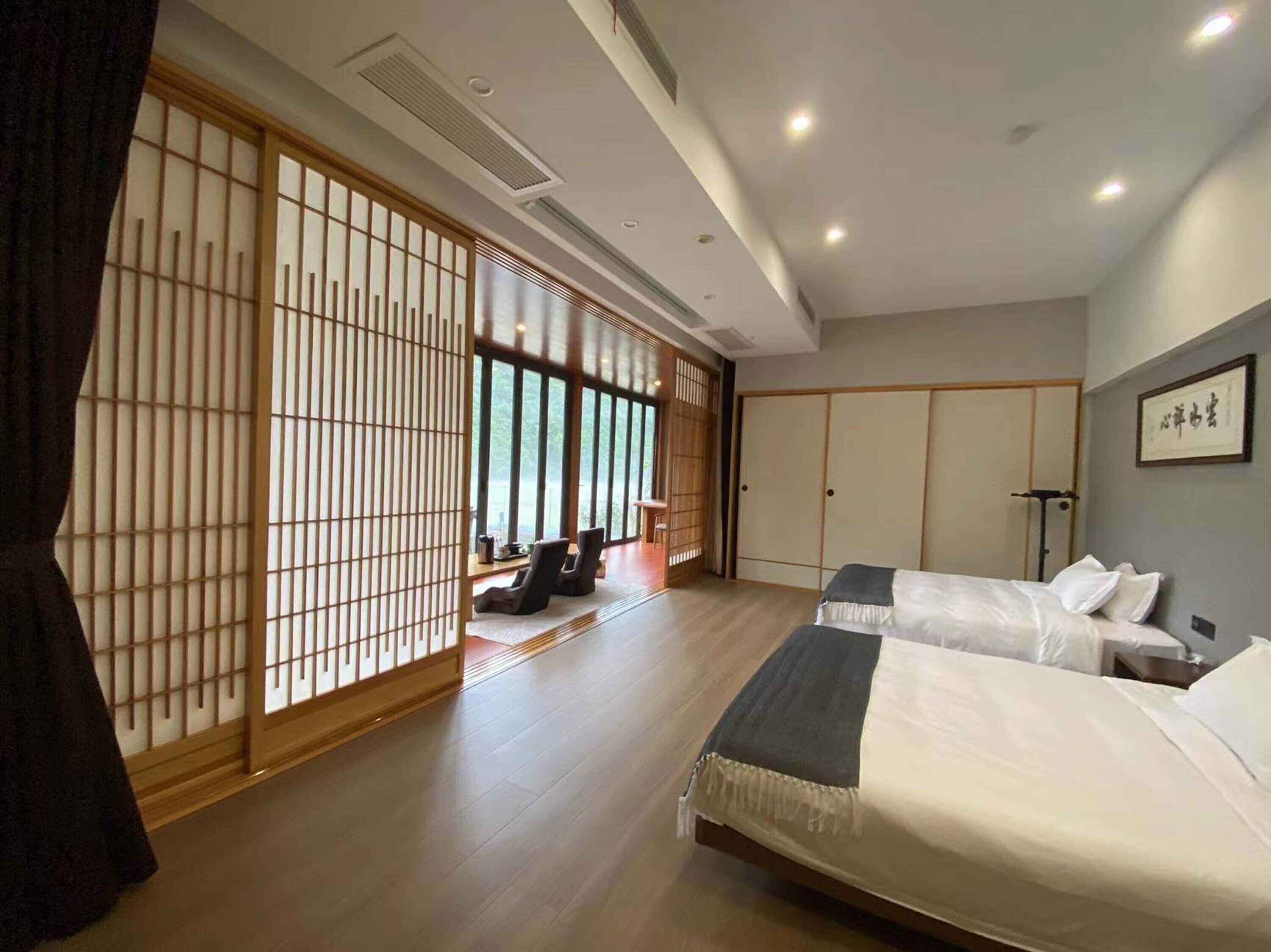 Una habitación tradicional japonesa con suelo de tatami, pantalla shoji y futón.