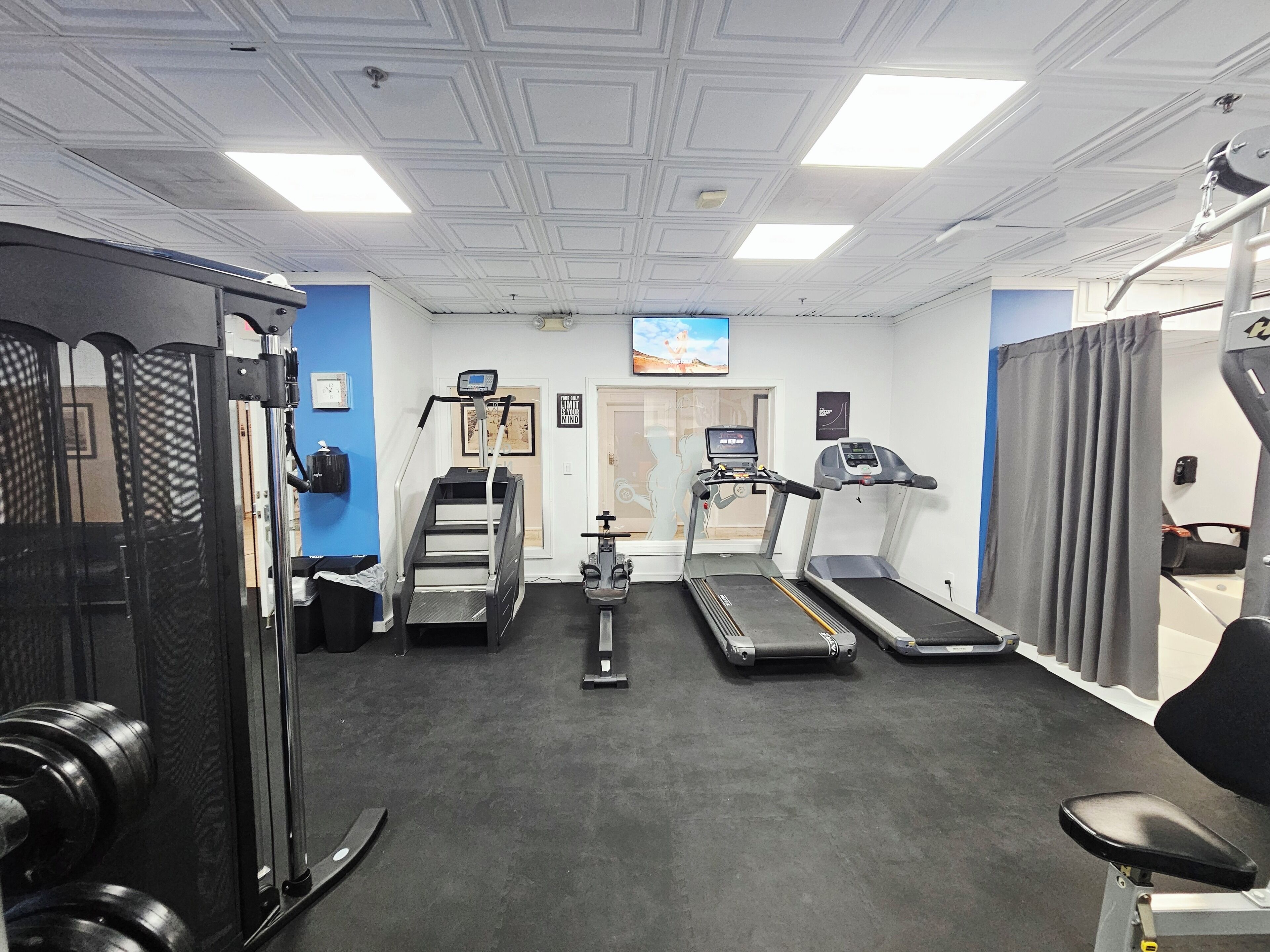 A gym with treadmills, a stair climber, and weight machines.