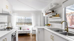 Eine moderne Küche mit weißen Schränken, einem eingebauten Backofen und einem Fenster mit Blick auf die Stadt.