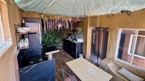 A compact kitchen with a gas stove, a sink, and a small dining area with a table and chairs. - RUSTIC CABIN IN THE CENTER OF TEPOZTLAN (Tepoztlán)