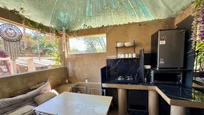 A compact kitchen with a dining area, including a table and chairs, a refrigerator, and a microwave. - RUSTIC CABIN IN THE CENTER OF TEPOZTLAN (Tepoztlán)