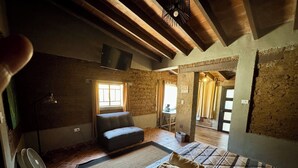 A cozy room with a bed, a chair, a fan, and a window. - RUSTIC CABIN IN THE CENTER OF TEPOZTLAN (Tepoztlán)