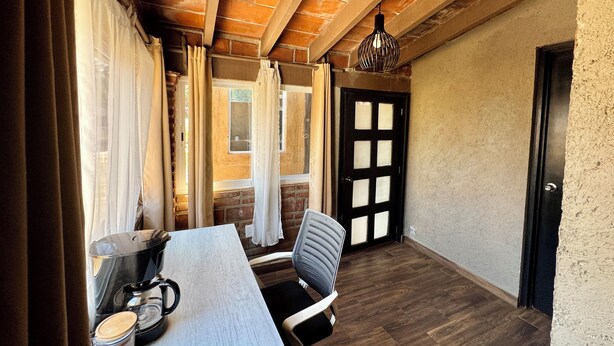 A room with a wooden ceiling, a table with a kettle and jars, a chair, and a door with a window. - RUSTIC CABIN IN THE CENTER OF TEPOZTLAN (Tepoztlán)