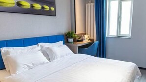 A hotel room with a bed, a desk with a chair, a potted plant, and a window with curtains. - 7 Days Premium Hotel (Beijing Qinghe Yongtaizhuang Metro Station) (Beijing)