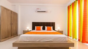 A modern bedroom with a large bed, wooden wardrobe, and bright curtains. - Ravo Residence (Galle)