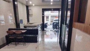 Un corridoio pulito, rivestito di piastrelle, con una reception e sedute, che conduce a un ingresso ben visibile.