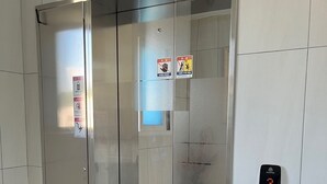 A modern elevator with a metallic finish, a control panel with a digital display, and safety signs on the wall. - Incheon Airport ANN Guesthouse (Incheon)