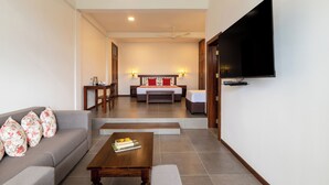A modern living room with a sofa, coffee table, and a flat-screen TV mounted on the wall. - Ruvinya Hills Luxury Bungalow (Lindula)