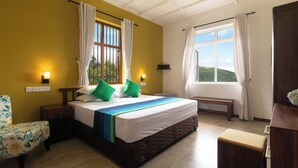 A room with a bed, a chair, a bench, and a window with curtains. - Ruvinya Hills Luxury Bungalow (Lindula)