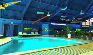 Una piscina interior con sillas de descanso, plantas en macetas y un reloj en la pared.