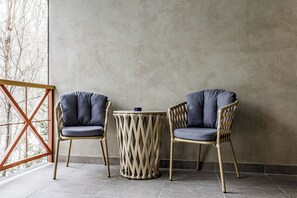 Dos sillas con cojines, una mesa redonda y un suelo de madera.