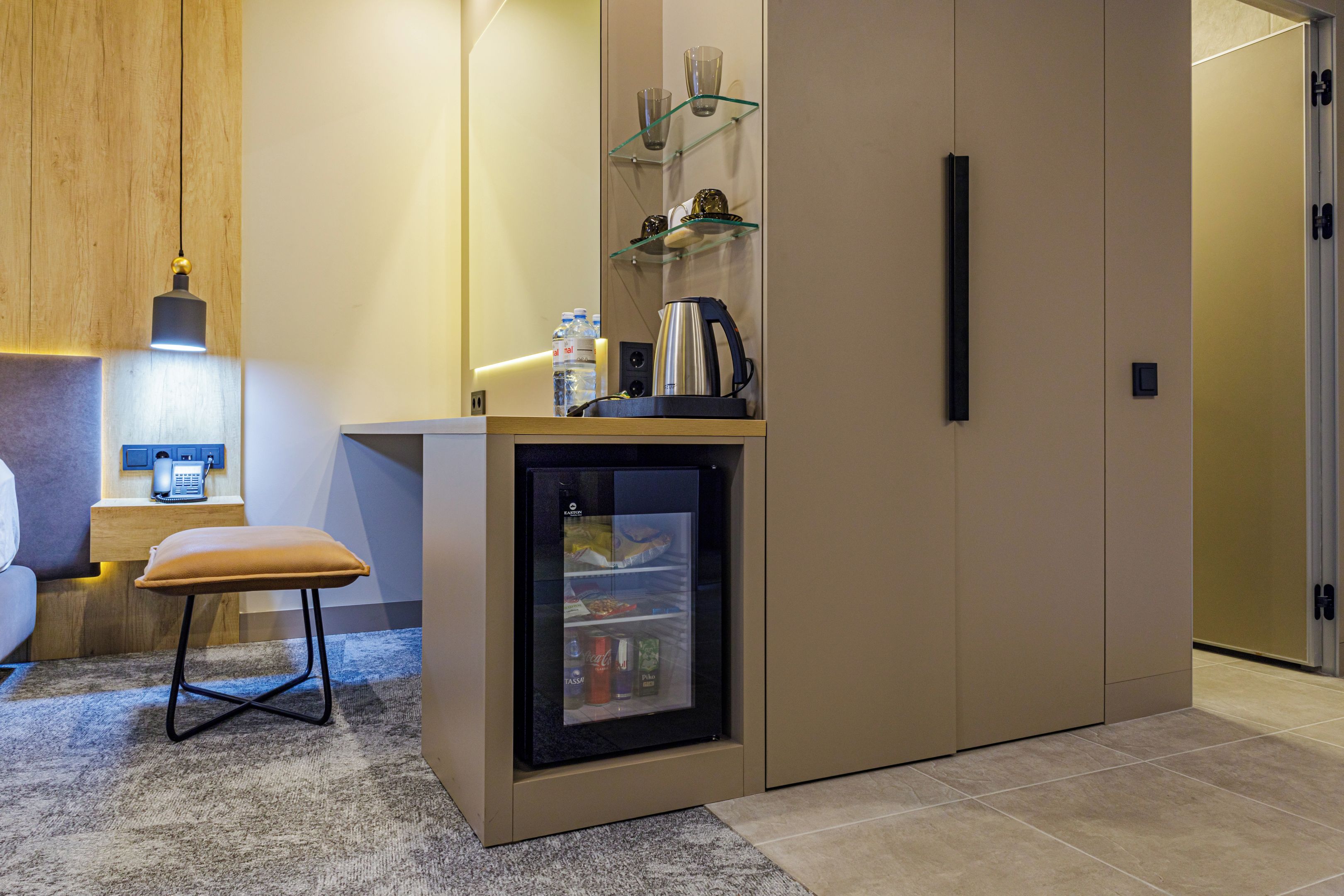 A compact kitchenette with a refrigerator, a coffee machine, and a small countertop.