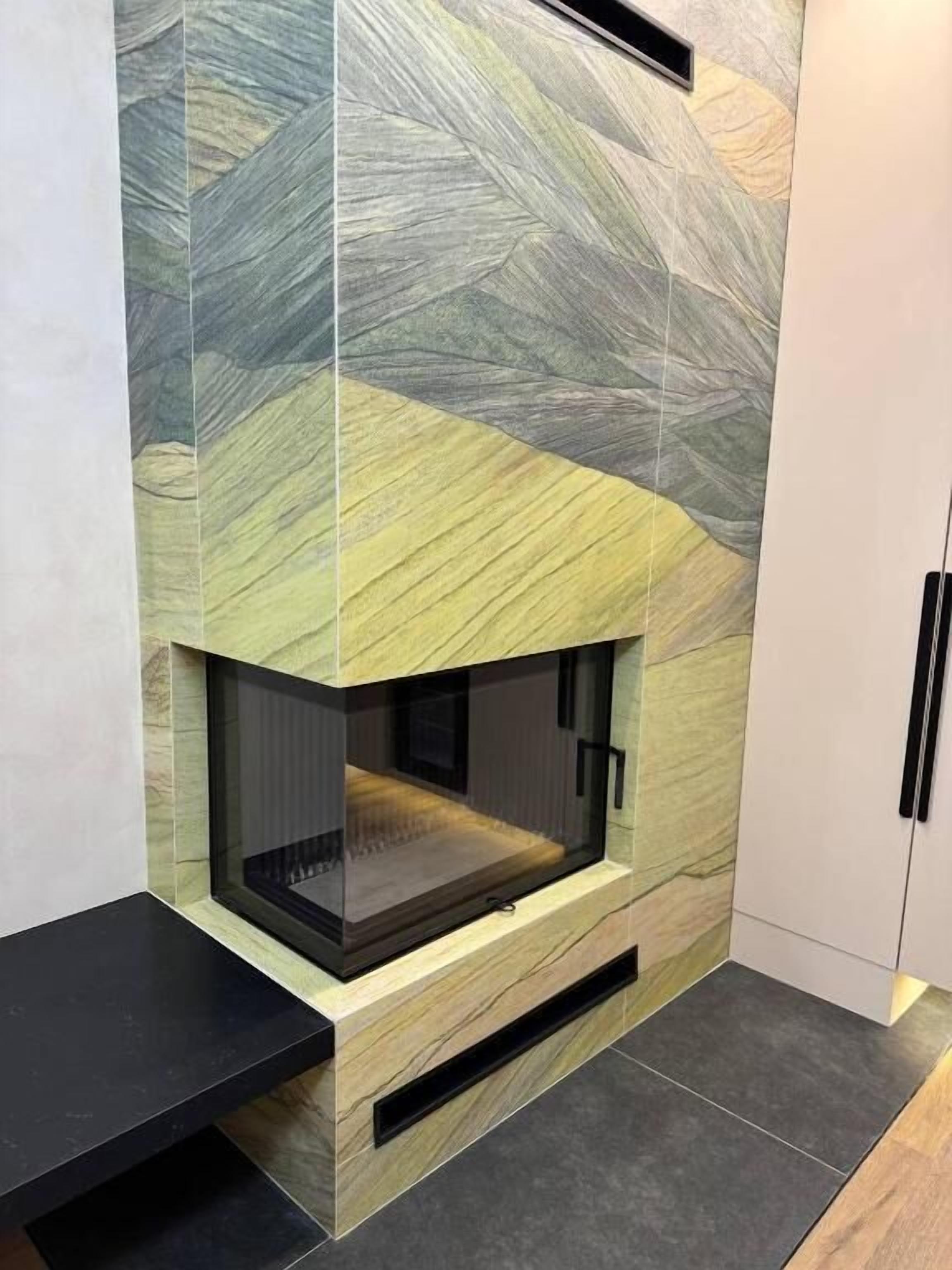 A modern fireplace with a geometric tile design, integrated into a wall with a built-in bench below.