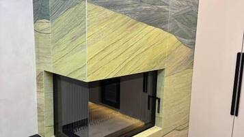 A modern fireplace with a geometric tile design, integrated into a wall with a built-in bench below.