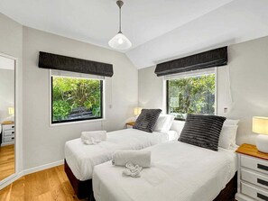 A hotel room with two beds, a wooden floor, and windows with views of greenery. - Queenstown Family Base, 100m to the Lake (Queenstown)