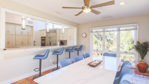 A modern kitchen with a large island, bar stools, and a dining table. - Private Access to Beach Boardwalk 4; FREE Amenity Card Privileges; Back Deck w/ Private Hot Tub! (Seabrook Island)