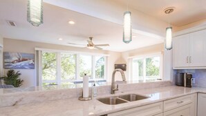 A modern kitchen with a large island, stainless steel appliances, and pendant lighting. - Private Access to Beach Boardwalk 4; FREE Amenity Card Privileges; Back Deck w/ Private Hot Tub! (Seabrook Island)