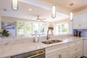 A modern kitchen with a large island, stainless steel appliances, and pendant lighting. - Private Access to Beach Boardwalk 4; FREE Amenity Card Privileges; Back Deck w/ Private Hot Tub! (Seabrook Island)