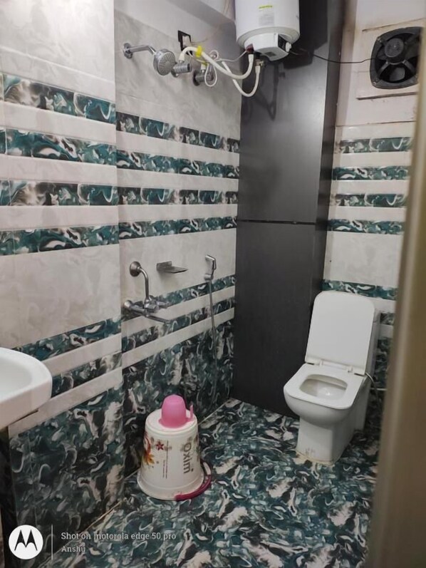 A bathroom with a toilet, sink, and shower. - Hotel Vikrant (Deoghar)
